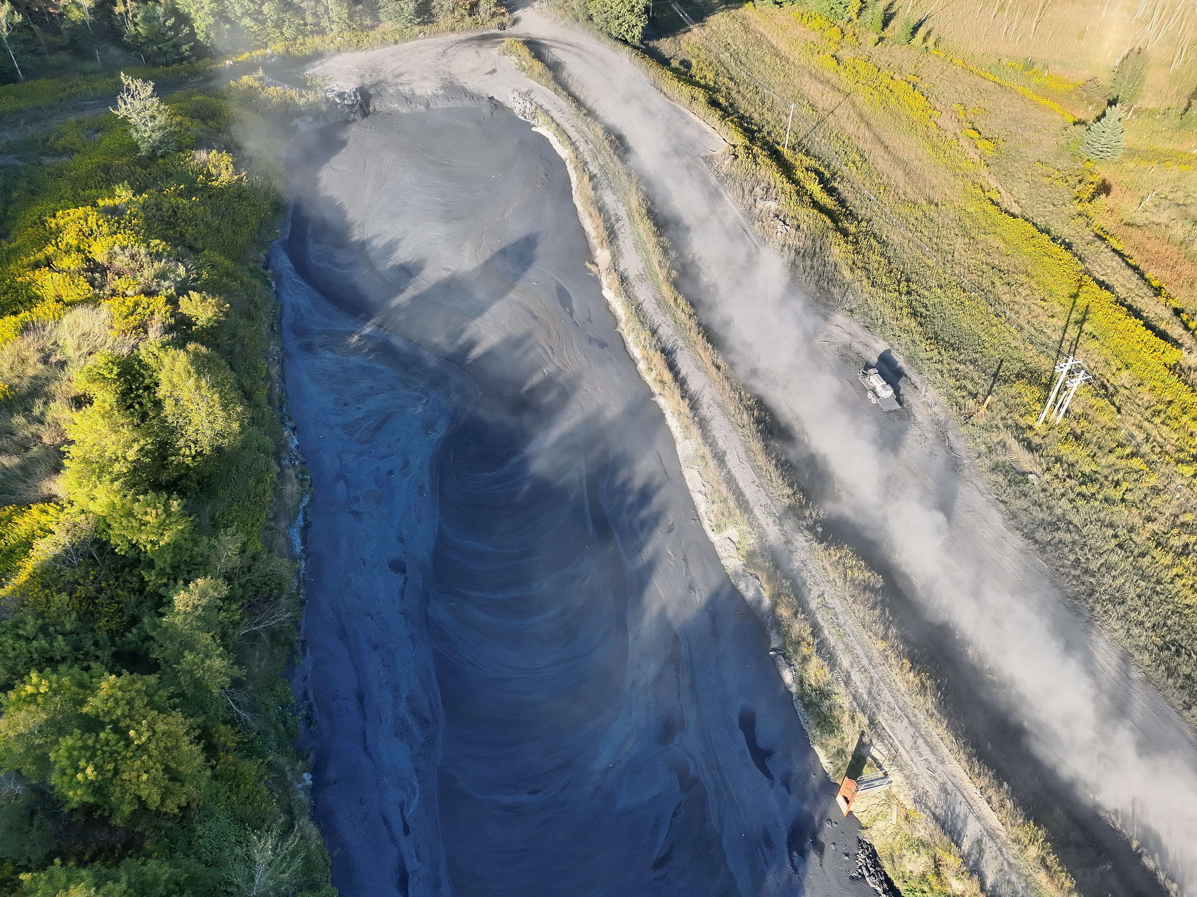 Aerial construction progress view of active earthwork and haul road